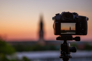 detalle de camara negra DSLR con focus en la puesta del sol